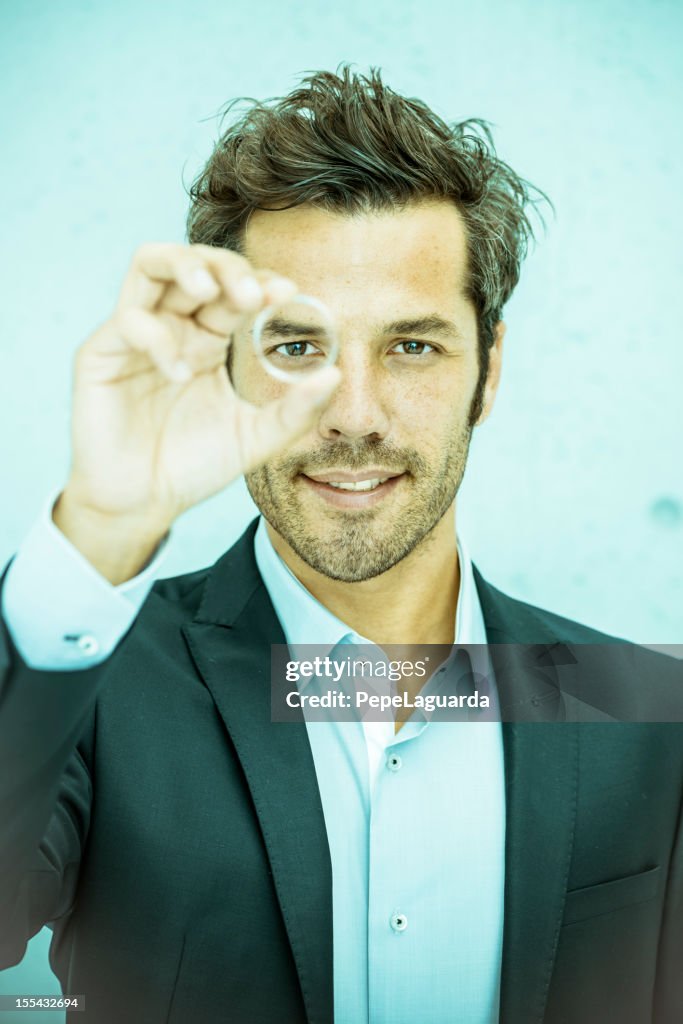 Businessman looking through a round lens