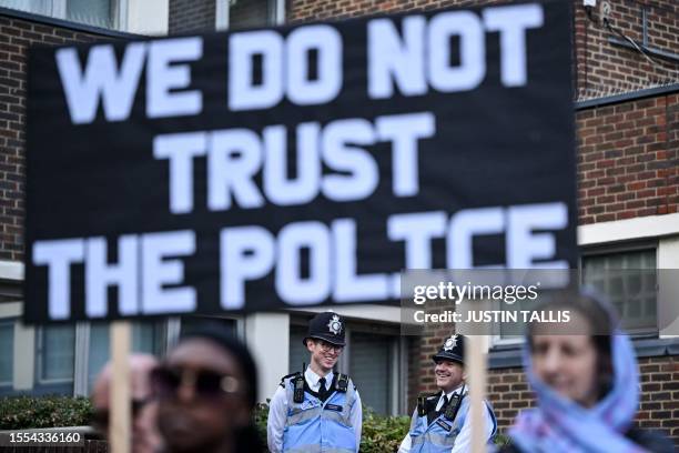 Demonstrators holding placards reading messages against the Metropolitan Police also called the MET police, gather outside a MET Police Station, in...