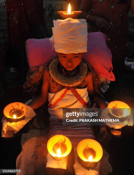 Young Nepalese Hindu devotee holds burning oil lamps on his head and palms for six hours on the tenth day of Hindu's biggest festival, Dashain , in...