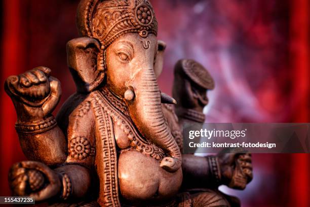 a statue of ganesha, a deity of india on red background - ganpati photos stock pictures, royalty-free photos & images