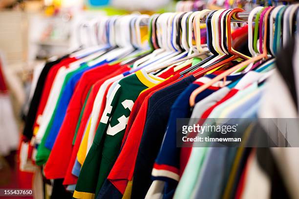 ropa de rack completo de camisetas en una tienda de artículos de segunda mano - discount store fotografías e imágenes de stock