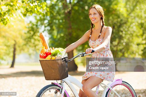 junge frau reiten fahrrad mit einkaufstasche voller lebensmittel. - shopping with bike stock-fotos und bilder