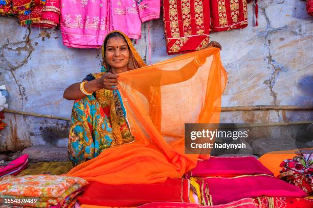 colores de la india - mujer vendiendo telas de colores en el bazar local - bindi fotografías e imágenes de stock