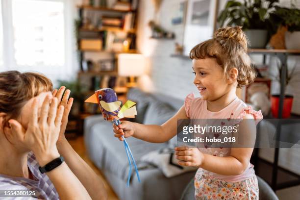 toddler girl playing with her mother at home - origami instructions stock pictures, royalty-free photos & images