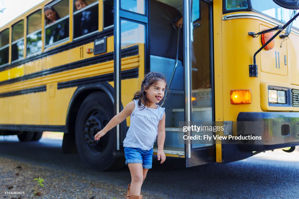 Cute Hispanic Girl Getting Off School Bus After School HighRes Stock