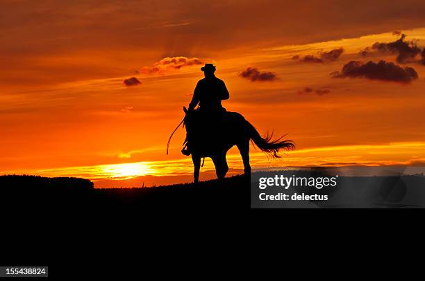 cowboy rides into the sunset - cowboy riding stock pictures, royalty-free photos & images