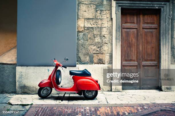 italian vintage red scooter in front of a house - vintage motorcycle stockfoto's en -beelden