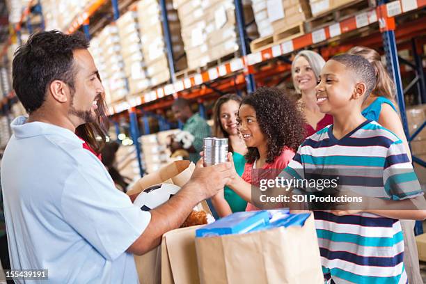 adultos e crianças com brinquedos voluntter alimentos de doação de caridade drive - father and children volunteering imagens e fotografias de stock