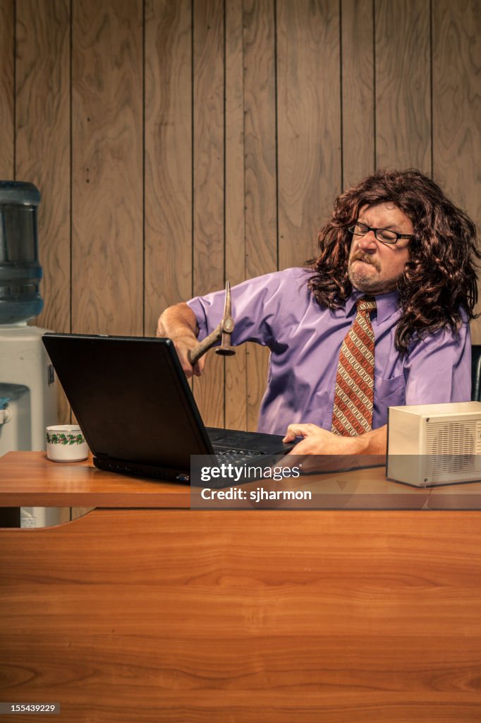 Aggressive Retro Office Worker Smashing his Computer with Hammer