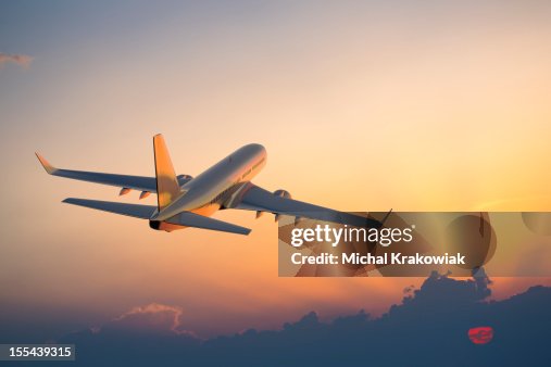 Passenger airplane flying above clouds during sunset Passenger airplane flying above clouds during sunset