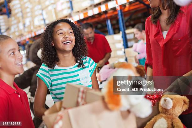 adulti e bambini giocattoli di natale donazione in beneficenza drive - child giving gift foto e immagini stock