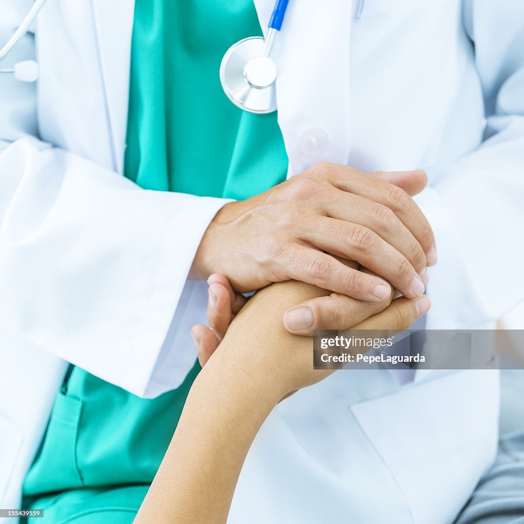 Doctor's hand consoling patient