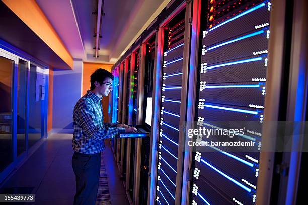 man standing in neon light with it servers - backup stockfoto's en -beelden