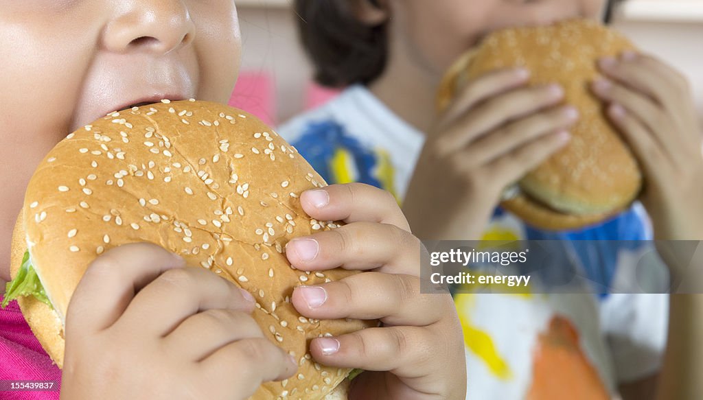 Menino e menina com hambúrgueres