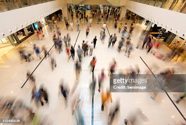 personnes marchant dans les boutiques - shopping in mall photos et images de collection