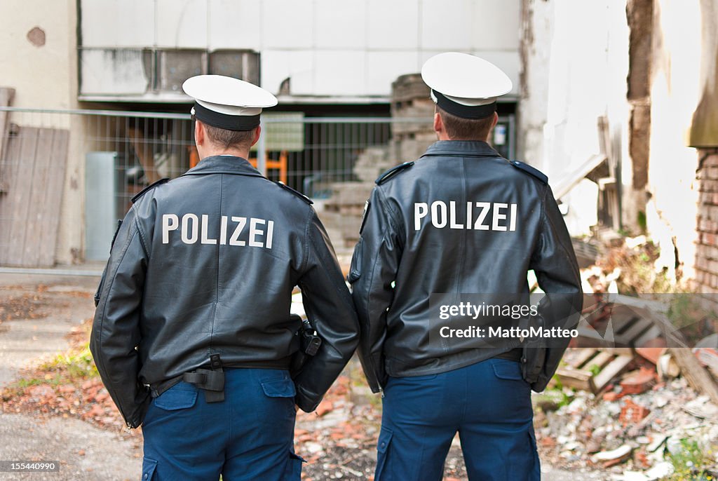 Dois agentes policiais estão mostrando suas costas