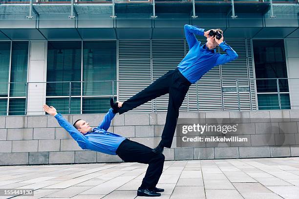 two businessmen with acrobatic skills work together - acrobatic activity stock pictures, royalty-free photos & images