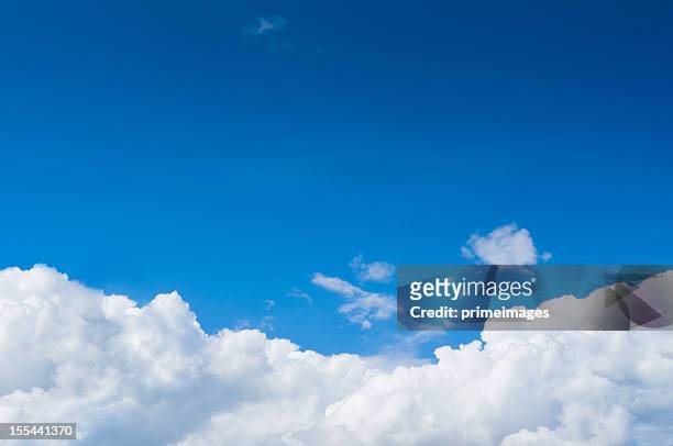 blue sky with dramatic white clouds below - cloud sky stockfoto's en -beelden