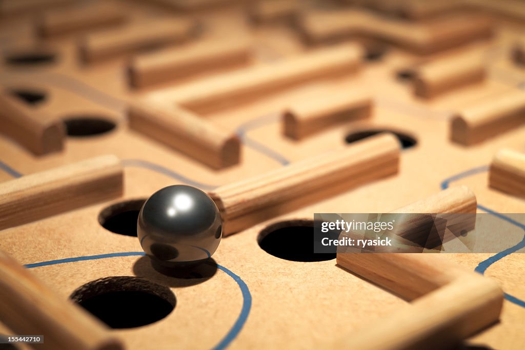 Closeup of Shiny Metal Ball Navigating A Labyrinth Maze