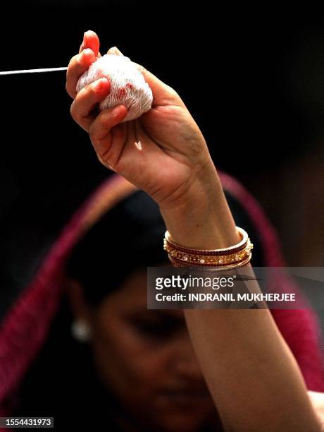 Married Hindu woman holds a ball of thread which she winds around a banyan tree on the occasion of 'Vata Poornima' in Mumbai on June 15, 2011. On the...