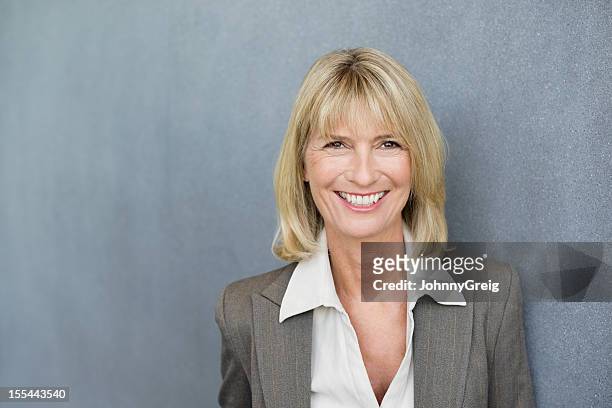 glücklich weibliche executive - portrait grey background stock-fotos und bilder