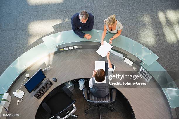 business couple at reception desk - receiving paper stock pictures, royalty-free photos & images