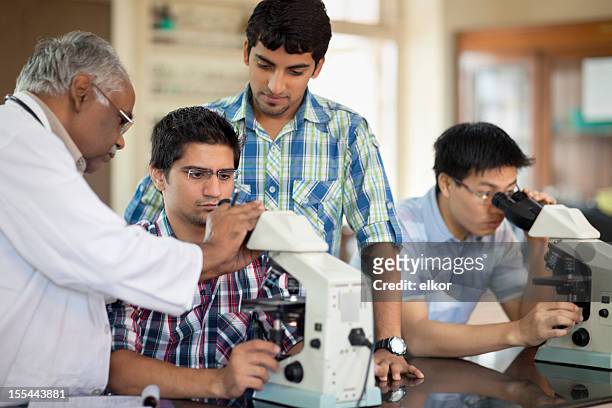 indian professor teaching students microscopy - science demonstration stock pictures, royalty-free photos & images