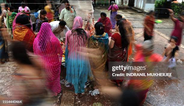 Married Hindu women tie threads around a banyan tree on the occasion of 'Vata Poornima' in Mumbai on June 15, 2011. On the occasion of Vata Savitri...