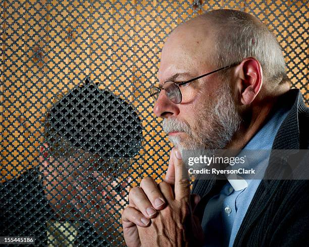 a patron giving a confession through a grate - confession religion stock pictures, royalty-free photos & images