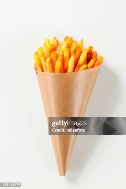 french fries in a paper cone - frites stockfoto's en -beelden