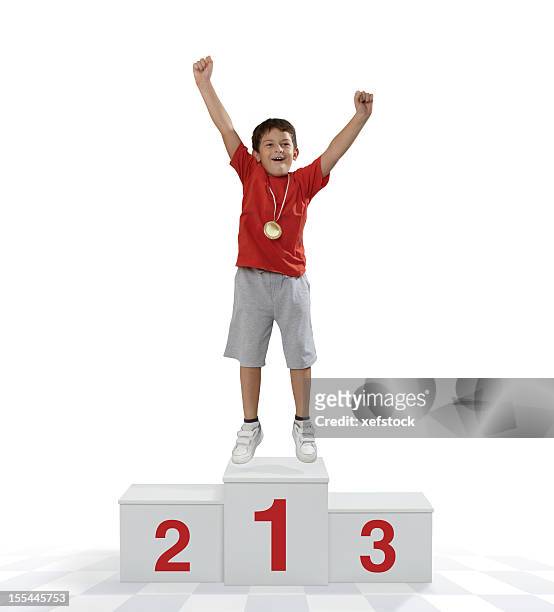 child standing on a place podium in first place cheering - winners podium stockfoto's en -beelden