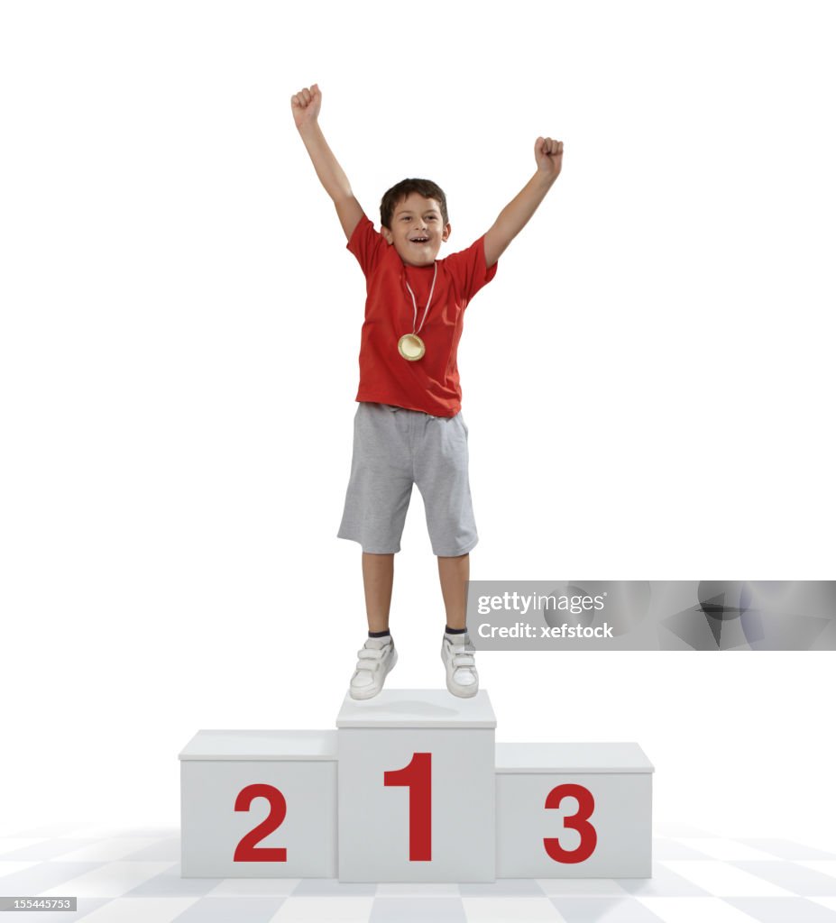 Child standing on a place podium in first place cheering