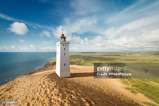 lighthouse in the dunes - vuurtoren stockfoto's en -beelden