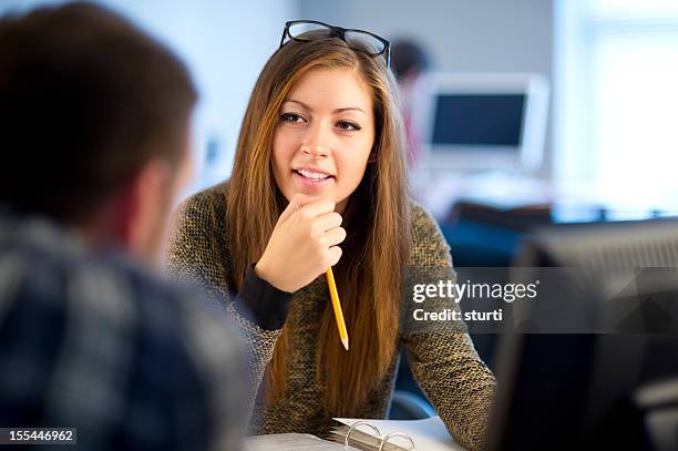 young female office worker chatting to colleague - administrative professional stock pictures, royalty-free photos & images