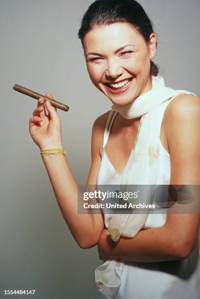 Caroline Grothgar, österreichische Schauspielerin, lachend mit Zigarre bei einem Fotoshooting im Studio, Deutschland 1996.