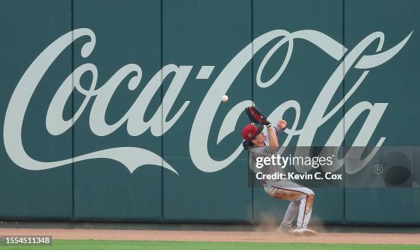 Corbin Carroll of the Arizona Diamondbacks fails to catch a deep fly ball hit for a double by Ozzie Albies of the Atlanta Braves in the first inning...