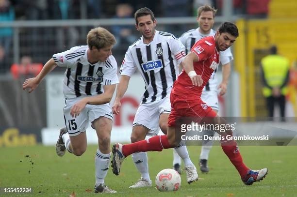 Adil Chihi of Cologne is challenged by Daniel Buballa and Leandro Grech of Aalen during the Second Bundesliga match between VfR Aalen and 1. FC Koeln...