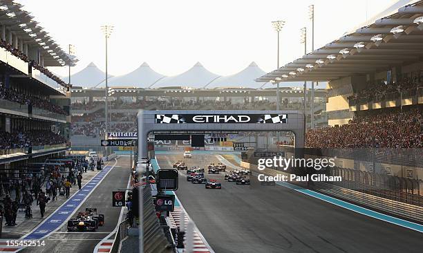 Sebastian Vettel of Germany and Red Bull Racing and Pedro de la Rosa of Spain and Hispania Racing Team queue up at the pitlane exit as Lewis Hamilton...