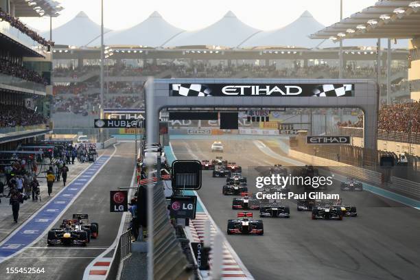 Sebastian Vettel of Germany and Red Bull Racing and Pedro de la Rosa of Spain and Hispania Racing Team queue up at the pitlane exit as Lewis Hamilton...