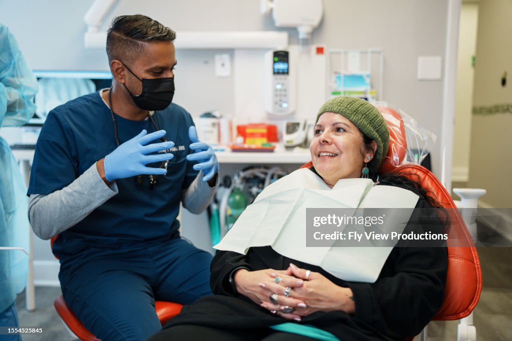 Female patient smiles as she consults with a dentist