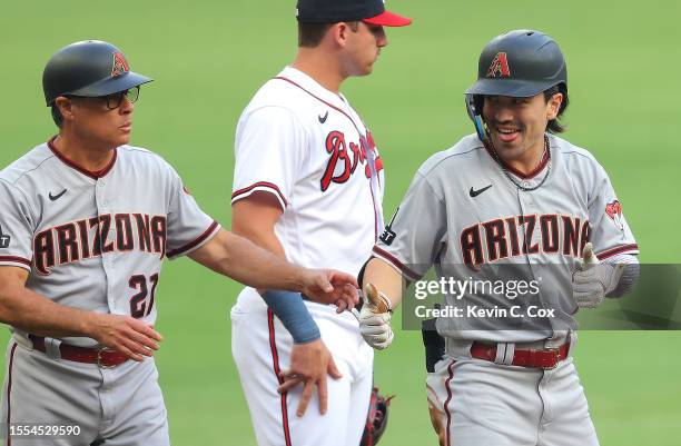 Corbin Carroll of the Arizona Diamondbacks reacts after hitting a RBI triple in the first inning against the Atlanta Braves at Truist Park on July...