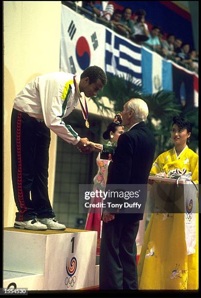 ANTHONY NESTY OF SURINAM COLLECTS HIS GOLD MEDAL AFTER CLAIMING VICTORY IN THE MENS 100 METRES BUTTERFLY IN SEOUL. NESTY WON THE GOLD WITH AN OLYMPIC...