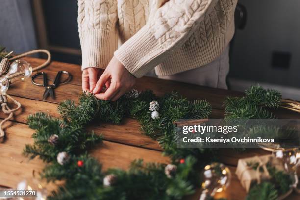 woman making christmas wreath at table, closeup - flower garland stock pictures, royalty-free photos & images