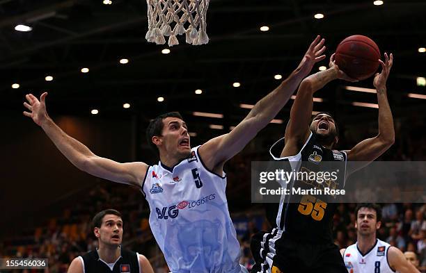 Keith Waleszkowski of Bremerhaven challenges for the ball with Joshua Jackson of Ludwigsburg during the Beko BBL basketball match between Eisbaeren...