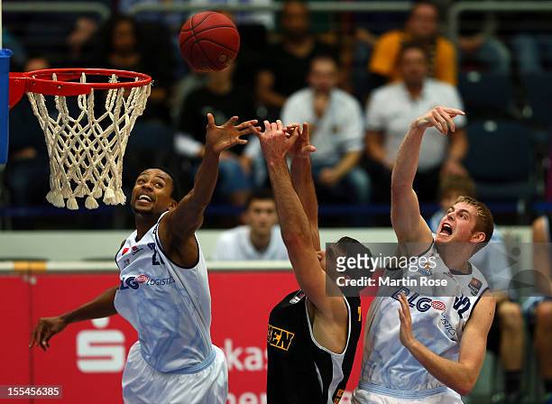 Alex Harris and Justin Stommes of Bremerhaven challenge for the ball with John Turek of Ludwigsburg during the Beko BBL basketball match between...