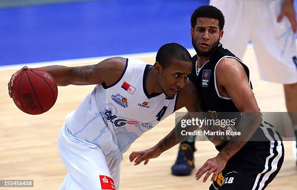 Stanley Burrell of Bremerhaven challenges for the ball with Joshua Jackson of Ludwigsburg during the Beko BBL basketball match between Eisbaeren...