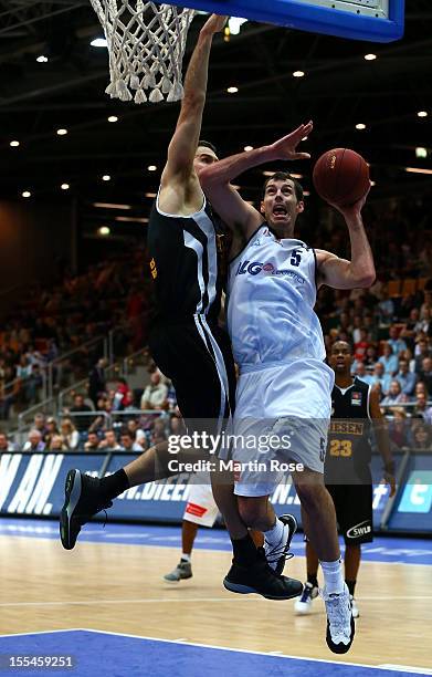 Keith Waleszkowski of Bremerhaven challenges for the ball with John Turek of Ludwigsburg during the Beko BBL basketball match between Eisbaeren...