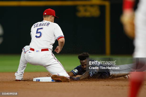 Randy Arozarena of the Tampa Bay Rays slides safely into second base with a double in the second inning as Corey Seager of the Texas Rangers applies...