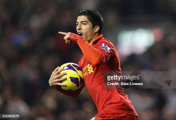 Luis Suarez of Liverpool celebrates scoring his team's first goal to make the score 1-1 during the Barclays Premier League match between Liverpool...