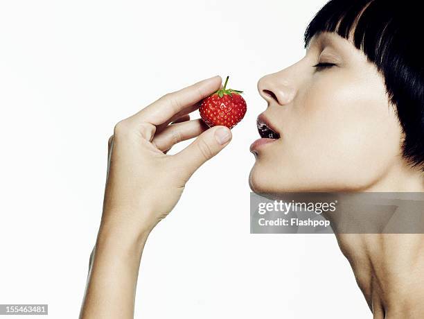 portrait of woman smelling a strawberry - mouth open profile stock pictures, royalty-free photos & images